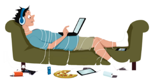 young man reclining on couch, watching computer wrapped up in cords with pizza on floor. Looks like he's been there a while.